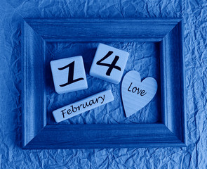 Wooden cubes hearts in a frame February 14 toned in modern trendy color classic blue