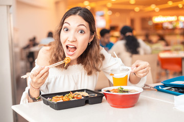 Asian woman eating Japanese bento lunchbox and miso soup in sushi bar