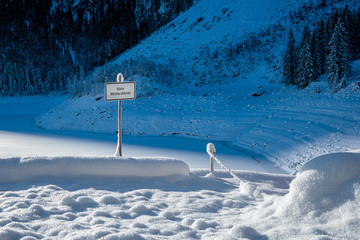 Schild : Kein Winterdienst in stark verschneiter Landschaft