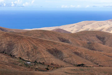 Panoramic view at landscape from viewpoint Mirador Morro Velosa on Fuerteventura with  multi colored volcanic mountainss and the Atlantic ocean in the background