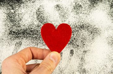 Fototapeta premium red heart on a black background. Sprinkle with flour. valentines day concept. Copyspace love concept.