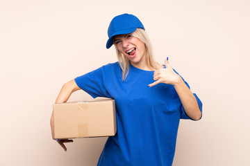 Fototapeta na wymiar Young delivery woman over isolated background making phone gesture