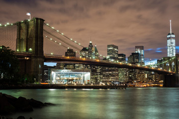 Low Angle View Of Brooklyn Bridge Over East River In Illuminated City