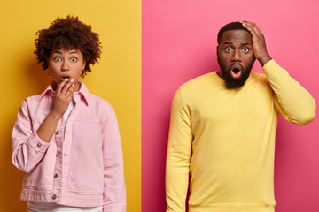 Shocked black female and male stare at camera, expresses great surprisement, open mouthes, hear...