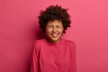 Overjoyed lovely woman laughs from happiness, rejoices hearing compliment and heartwaring words,...