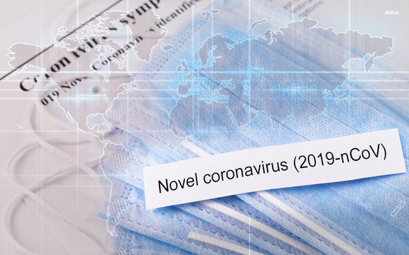 Novel coronavirus. Respirator masks closeup on the digital world map background, with crumpled paper with text Coronavirus, originating in Wuhan, China