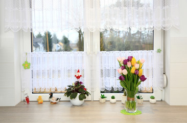Klorowe tulipany w wazonie na parapecie białego wspłóczesnego okna w kuchni. - obrazy, fototapety, plakaty