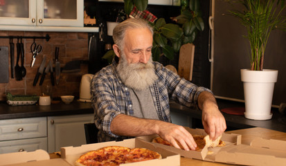 Close-up view of happy bearded senior man eating pizza