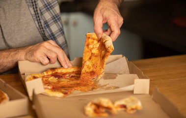 Hot pizza slice with melting cheese. Lunch or dinner delicious food italian traditional on wooden table in side view. Selective focus.