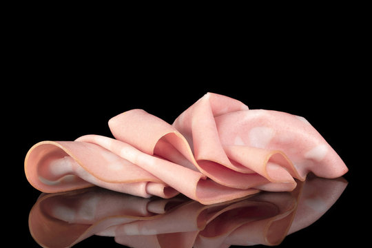 Slices of sausage iatlian mortadella with reflection isolated on the black background, close up, side view