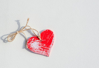 Vintage wooden red heart on a white patchy background. Сoncept of a love card