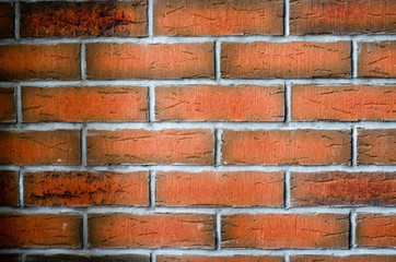 bright red orange brick wall with grey paint between bricks