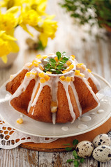 Easter yeast cake, traditional Easter yeast cake covered with icing and candied orange peel on a wooden table, close up