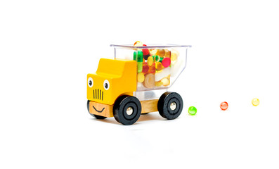 Truck car toy delivers vitamins pills medications for baby child on a white isolated background.