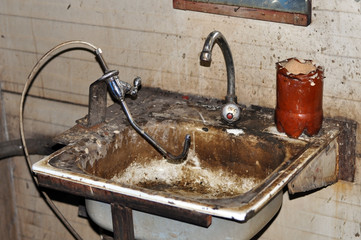 Dirty old sink for washing the hands of a workshop in a factory.