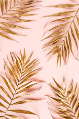 Pattern of golden tropical date palm leaves on pink background. Flat lay, top view minimal concept.