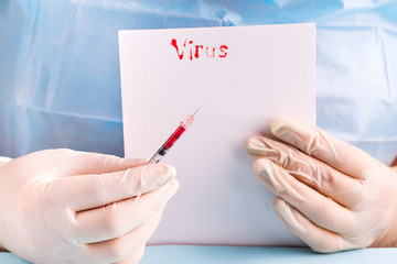 doctor's hand holding Syringe with blood on a blue background with white paper and the inscription Virus