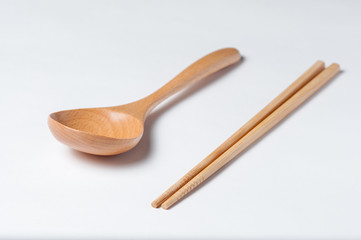 Cutlery made of wood. Wooden spoon and wooden chinese sticks on a white background.