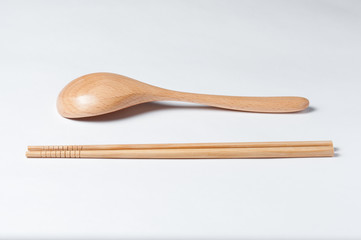 Cutlery made of wood. Wooden spoon and wooden chinese sticks on a white background.