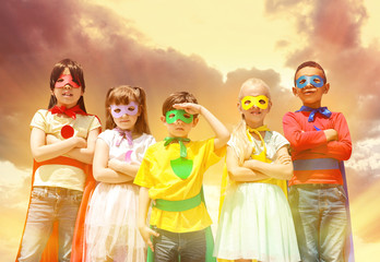 Cute little children dressed as superhero against sky