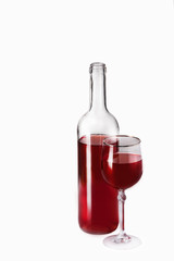 Bottle and glass of red wine on the table on a dark background.