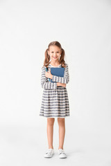 Cute little girl with book on white background
