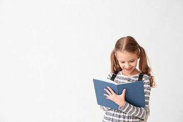 Cute little girl with notebook on white background