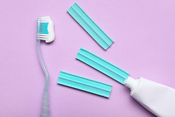 Tooth brush with paste and chewing gums on color background