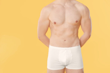 Fototapeta premium Handsome man in underwear on color background