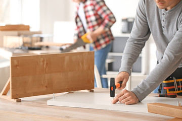 Handyman assembling furniture in workshop