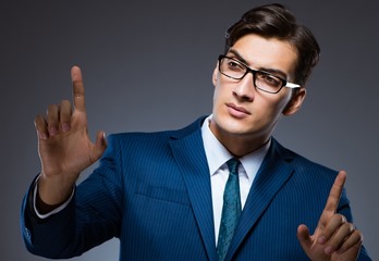 Businessman pressing virtual buttons on gray background