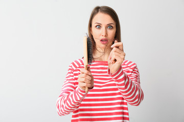 Young woman with hair loss problem on grey background