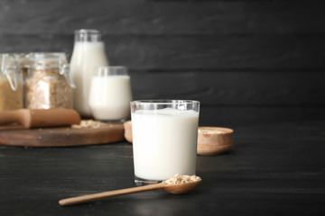 Glass of oat milk on dark table