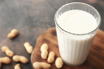 Glass of peanut milk on grey background, closeup