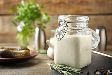 Jar of tasty sauce on wooden table