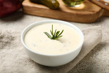 Bowl with tasty sauce on table