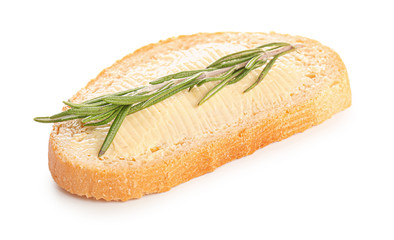 Slice of bread with butter and herbs on white background