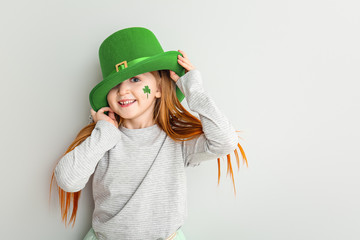 Funny little girl on white background. St. Patrick's Day celebration
