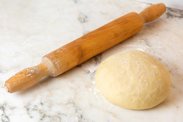 Fototapeta na wymiar rolling pin and fresh pie dough