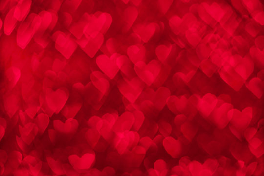 Valentine's day abstract background. Red gradient background with heart shaped bokeh effect. Valentines day, love, holiday concept. 