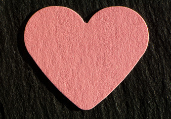 a pink heart in front of a black background