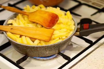 potatoes in a stone skillet and wooden spoons