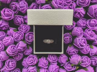 Ring for marriage proposal decorated with decorative flowers. Valentine’s Day background.