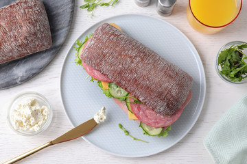 Tasty sandwich with ham served on white wooden table, flat lay