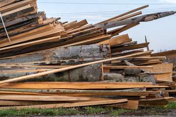 Stack od wooden boards prepared for cutting by chainsar for firewood.