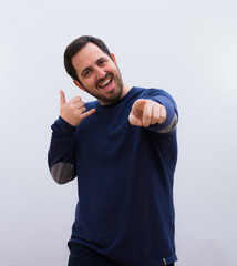 young handsome man smiling cheerfully and pointing to camera while making a call you later gesture,...