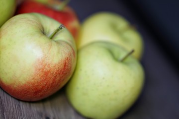 Red and green fresh apple fruit on the wood table.