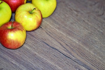 Red and green fresh apple fruit on the wood table.