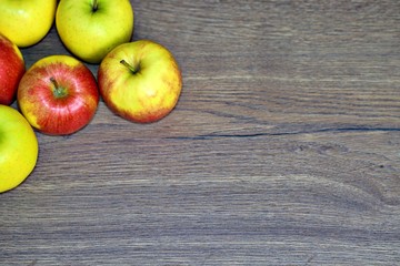 Red and green fresh apple fruit on the wood table.