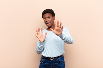 young pretty black womanfeeling terrified, backing off and screaming in horror and panic, reacting...